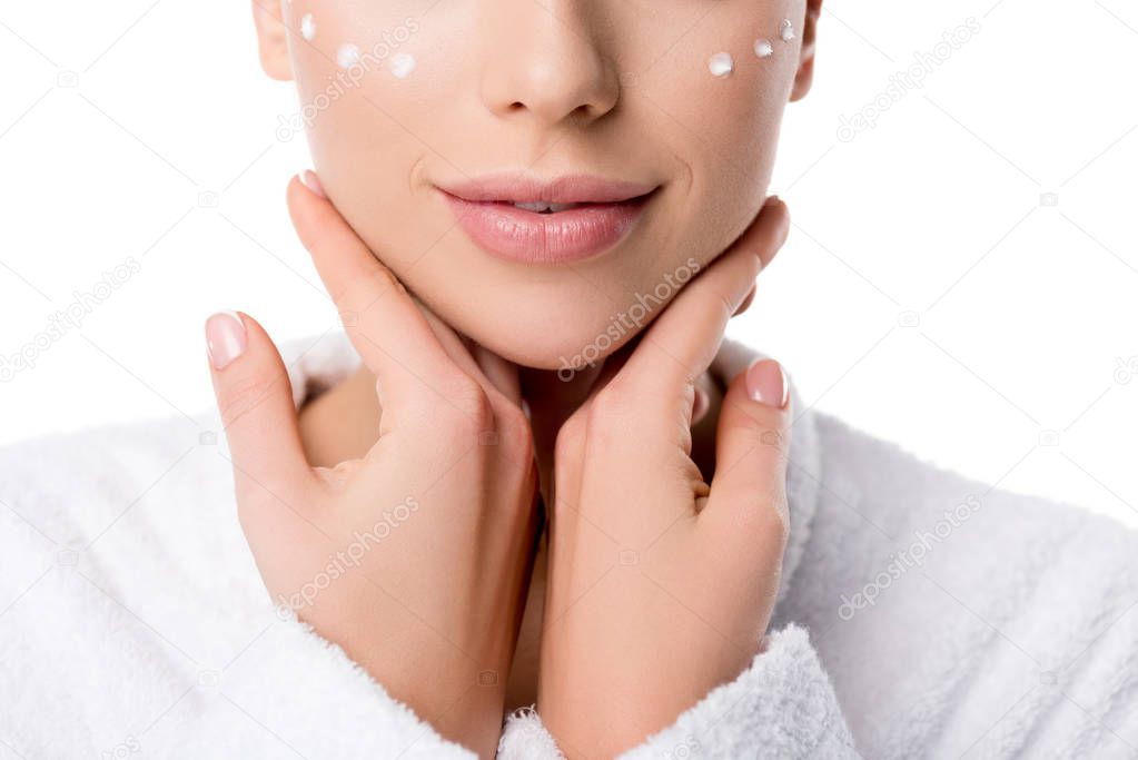 cropped view of woman with eye cream on face isolated on white