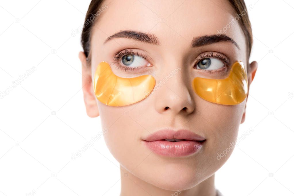 close up of beautiful woman with golden eye patches isolated on white