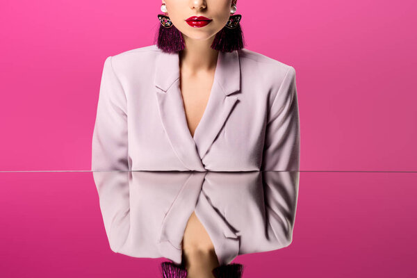 обрезанный вид гламурной женщины в формальной одежде, отражающейся в зеркале, изолированном на розовый
