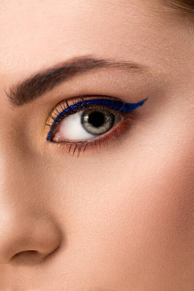 close up of female eye with blue eyeliner and perfect skin