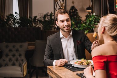 yakışıklı erkek kız restoranda taze salata ile besleme 
