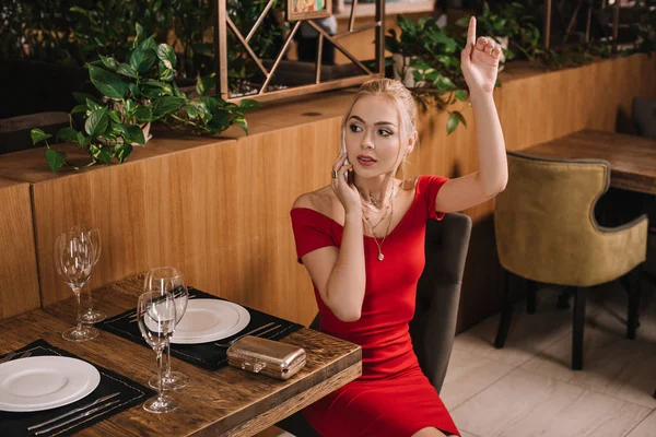 Attractive Woman Red Dress Sitting Restaurant Raising Hand — Stock Photo, Image