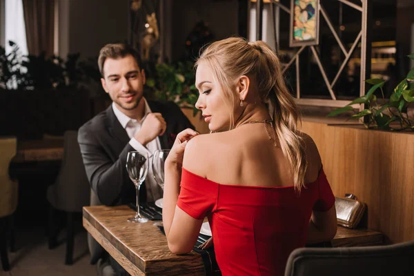 Namorado Bonito Olhando Para Namorada Atraente Vestido Vermelho Restaurante — Fotografia de Stock