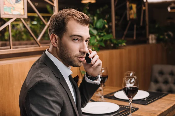 Bonito Homem Falando Smartphone Enquanto Sentado Restaurante — Fotografia de Stock