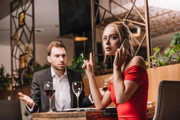 Dissatisfied Man Looking Girlfriend Talking Smartphone Dinner — Stock Photo, Image