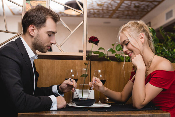 happy couple sharing dessert while sitting in restaurant 