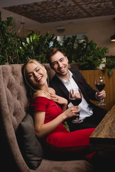 幸福的夫妇笑着 而拿着杯与红酒在餐厅 — 图库照片