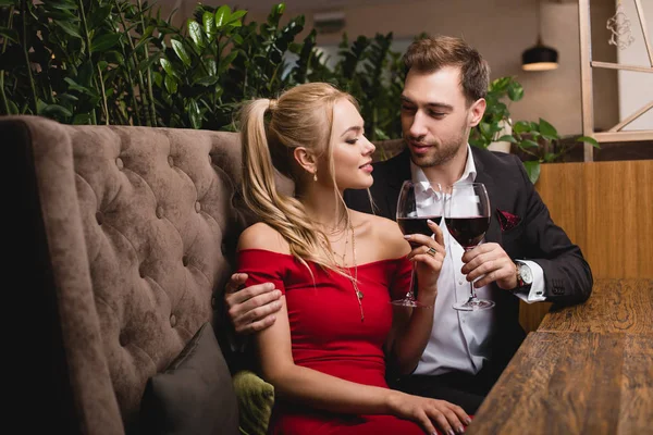 レストランで彼氏と赤ワインのグラスで乾杯の魅力的な女性 — ストック写真