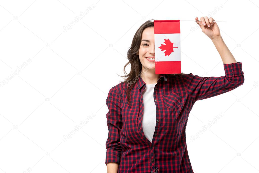 smiling woman holding canadian flag in front of face isolated on white