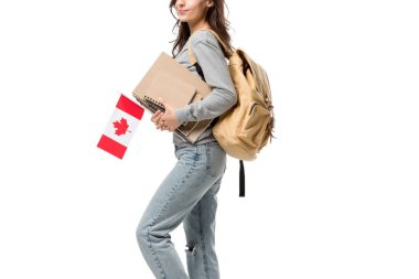 cropped view of female student with backpack and notebooks holding canadian flag isolated on white clipart