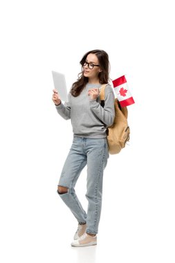 Kanada bayrağı tutarak ve dijital tablet üzerinde beyaz izole kullanma Gözlüklü kız öğrenci