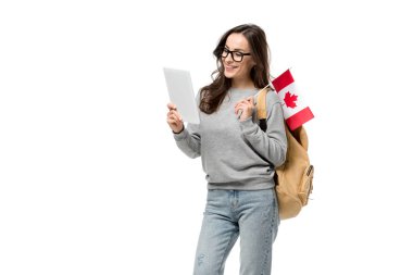 Kanada bayrağı tutarak ve dijital tablet üzerinde beyaz izole kullanma gözlük gülümseyen kız öğrenci