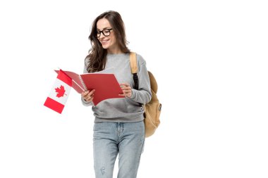 smiling female student with backpack holding canadian flag and notebook isolated on white