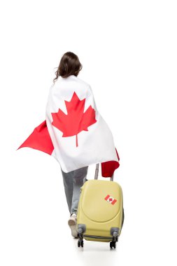 back view of woman covered in canadian flag with suitcase isolated on white, travel concept clipart