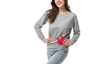 Kırpılan görünümü içinde rahat kıyafetler üzerinde beyaz izole akçaağaç yaprağı tutan kadın