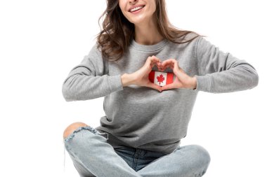Kırpılan eller üzerinde beyaz izole Kanada bayrağı rozeti olan kadın gösteren kalp simge görünümünü