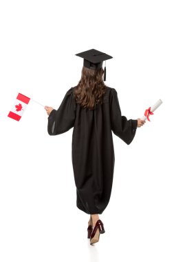 arkadan görünüşü holding Kanada bayrağı ve üzerinde beyaz izole diploma akademik elbise kız öğrenci