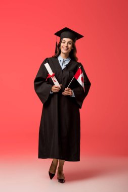 female student in academic gown holding canadian flag and diploma on living coral background clipart