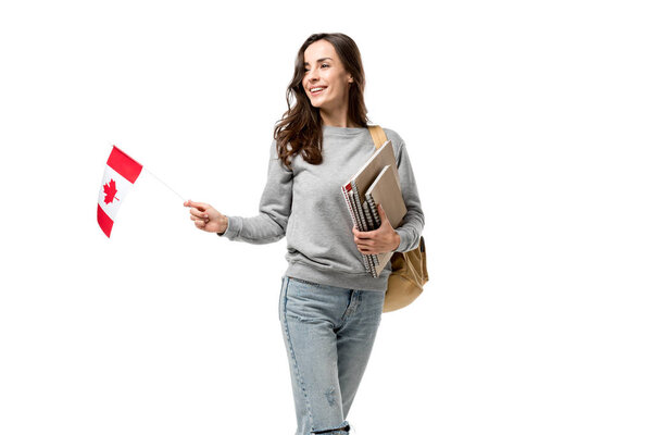 smiling female student with backpack and notebooks holding canadian flag isolated on white