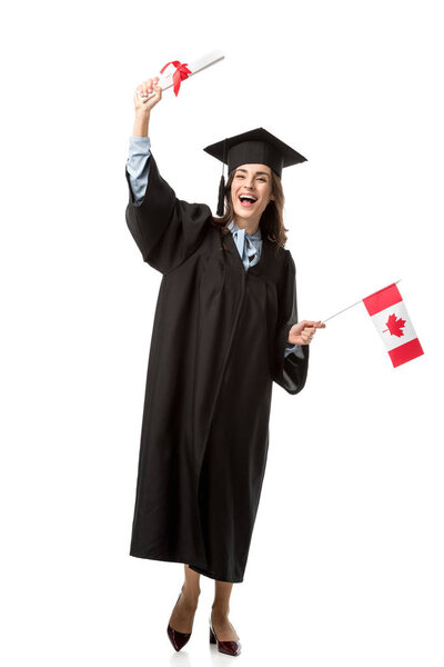 happy female student in academic gown holding canadian flag and diploma isolated on white