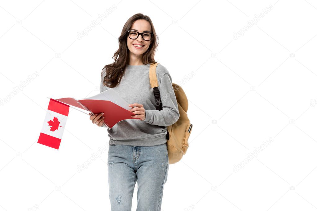 female student looking at camera and holding canadian flag with notebook isolated on white