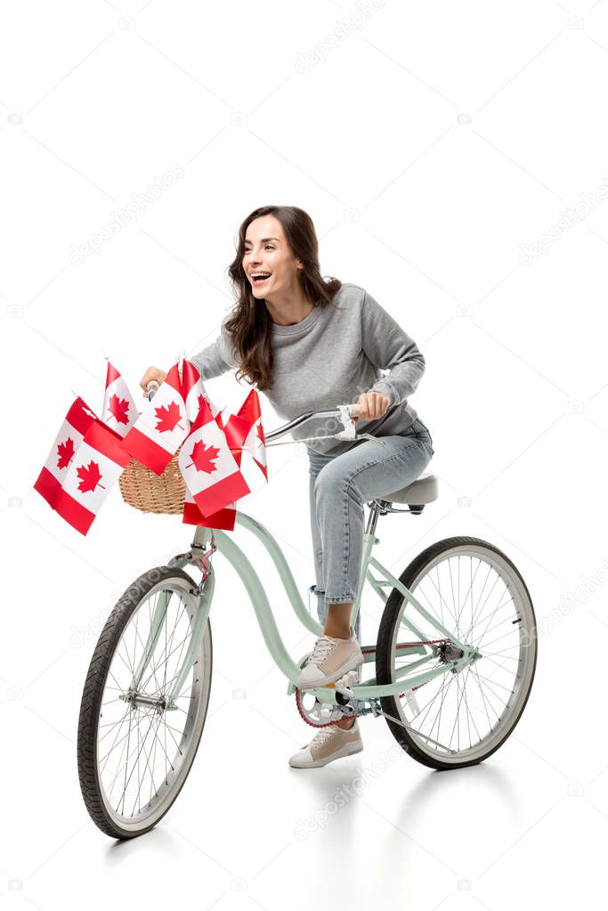 happy woman riding vintage bicycle with canadian flags isolated on white
