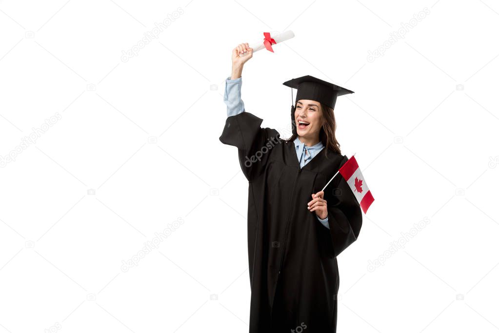 female student in academic gown cheering and holding canadian flag with diploma isolated on white