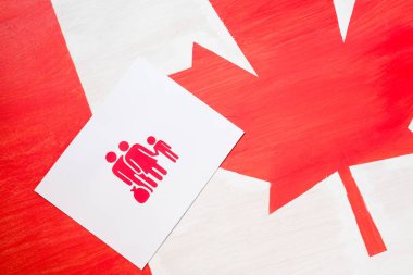 white card with family icon on canadian flag, immigration concept clipart