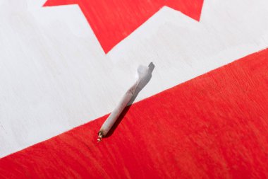 marijuana joint with canadian flag on background, marijuana legalization concept clipart