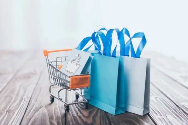 Foco Seletivo Sacos Compras Brinquedos Perto Pequeno Carrinho Compras Mesa — Fotografia de Stock