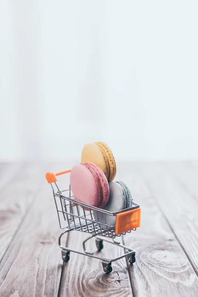 Süße Makronen Spielzeug Einkaufswagen Auf Holztisch — Stockfoto