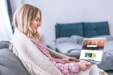 ekranda shutterstock Web sitesi ile dizüstü bilgisayar kullanarak ve kredi kartı tutan çekici sarışın kadın 