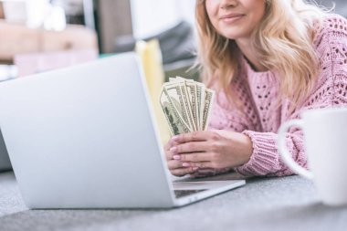 Kırpılan doları banknot dizüstü yalan süre tutan neşeli kadın görünümünü
