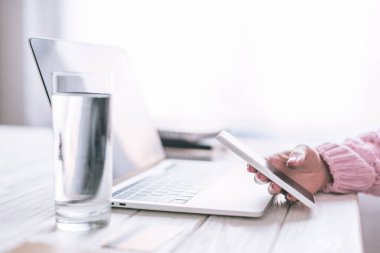  kadın freelancer işyerinde smartphone kullanarak görünümünü kırpılmış