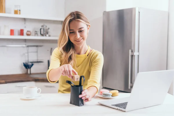 Attractive Woman Putting Small Paper Box Black Shopping Bag Kitchen — Stock Photo, Image