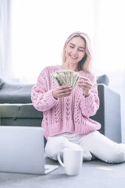 Χαρούμενη Γυναίκα Ψάχνει Στο Δολάριο Χαρτονομίσματα Ενώ Κάθεστε Κοντά Φορητό — Φωτογραφία Αρχείου