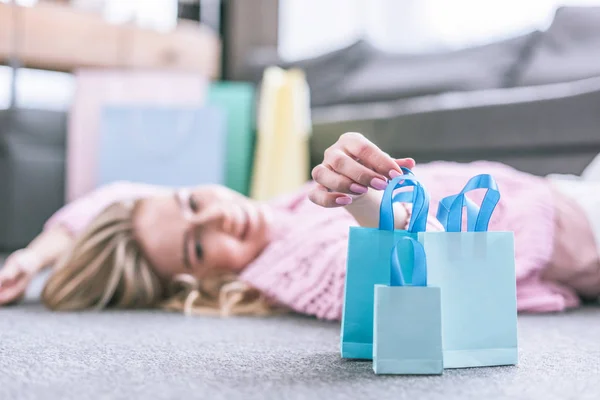 Foco Seletivo Sacos Compras Com Mulher Feliz Deitada Chão Segundo — Fotografia de Stock