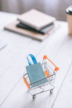 Dekoratif alışveriş çantası sepeti ahşap masa üzerinde seçici odak 
