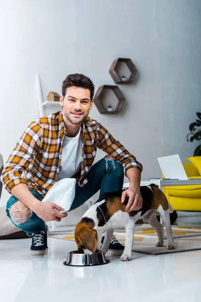 Handsome Smiling Man Feeding Beagle Dog Living Room — Stock Photo, Image