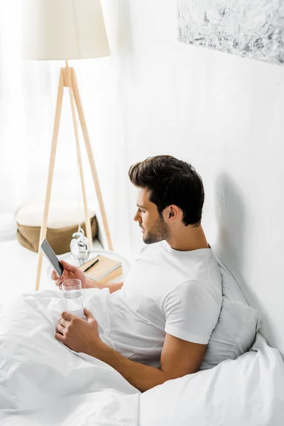 Young Man Glass Water Using Smartphone Resting Bed — Stock Photo, Image