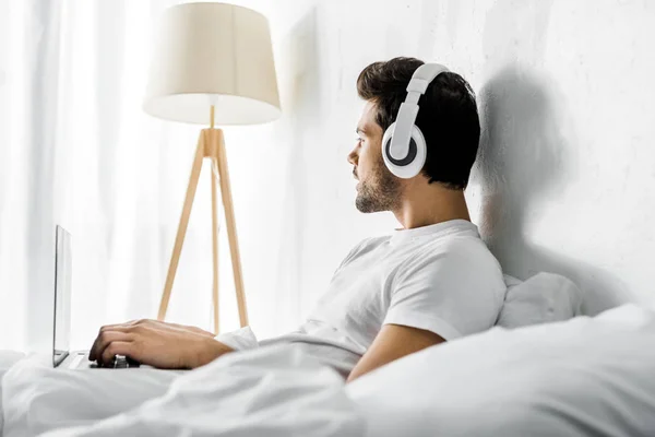 Thoughtful Man Listening Music Headphones Laptop Bed — Stock Photo, Image