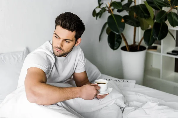 Thoughtful Young Man Pajamas Holding Cup Coffee Bed — Stock Photo, Image