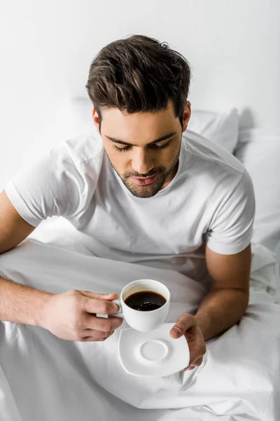 Stilig Leende Man Pyjamas Holding Kopp Kaffe Sängen — Stockfoto