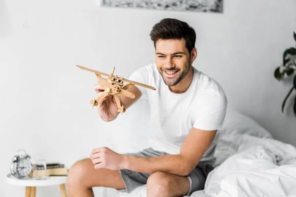 Sorridente Giovane Uomo Che Gioca Con Aeroplano Giocattolo Legno Camera — Foto Stock