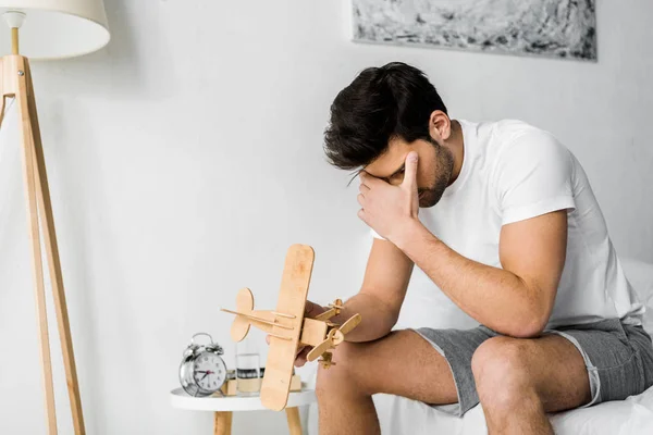 Upset Man Holding Wooden Toy Airplane Bedroom — Stock Photo, Image