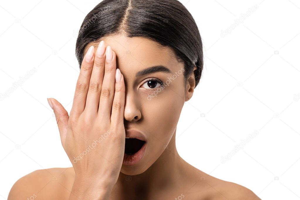 shocked young african american woman with open mouth closing eye with hand and looking at camera isolated on white