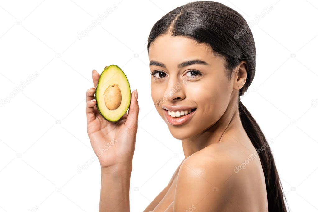 beautiful naked african american woman holding avocado and smiling at camera isolated on white  