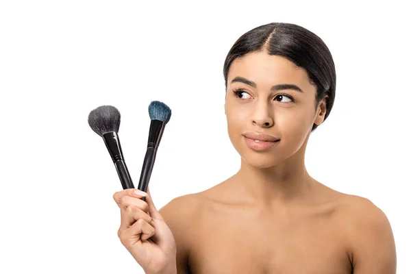 Hermosa Mujer Afroamericana Sonriente Sosteniendo Pinceles Maquillaje Mirando Hacia Otro — Foto de Stock