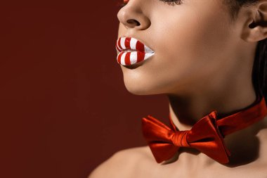 Kırpılan kadeh kırmızı papyon ve burgundy üzerinde izole çizgili kırmızı ve beyaz dudaklar ile Afrikalı-Amerikalı kadın