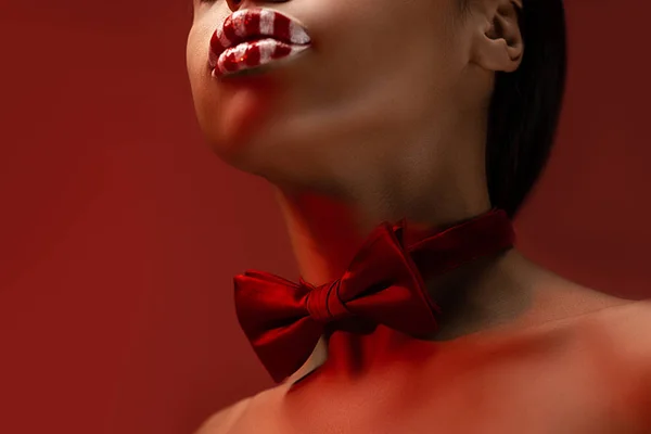 赤い蝶ネクタイとブルゴーニュに分離されたストライプの唇を持つ魅惑的な若いアフリカ系アメリカ人女性のクロップ撮影 — ストック写真